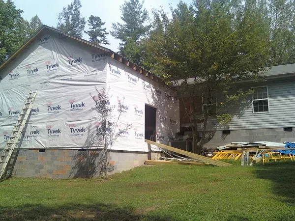 Tyvek wrapped gable on a new room addition beside an existing home in Mustang
